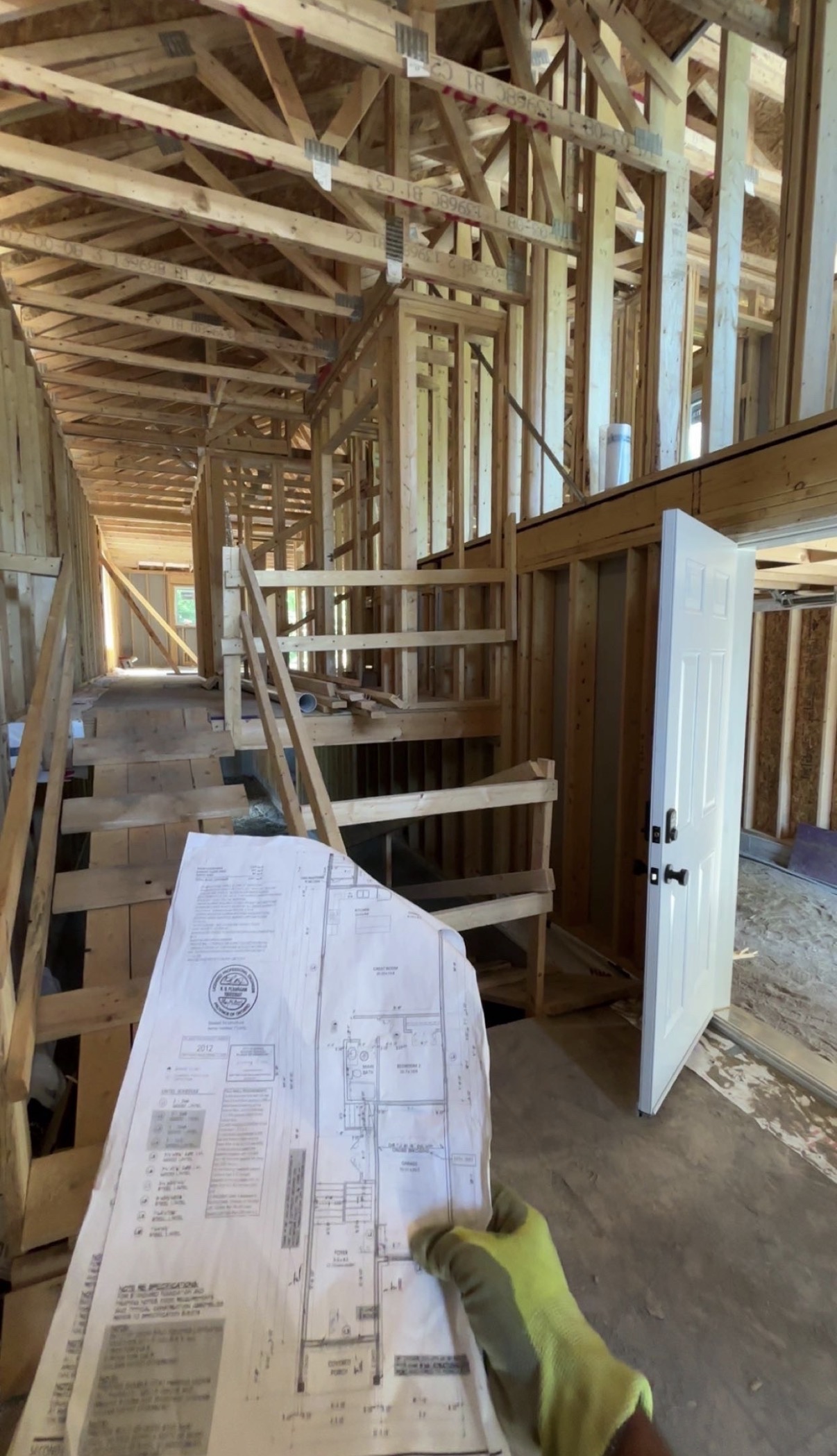 Construction framing site with drawings in hand.